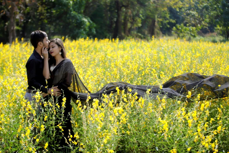 a man and woman standing in a field of yellow flowers, a picture, by Sudip Roy, romanticism, cinematic movie photo, fan favorite, guwahati, kissing