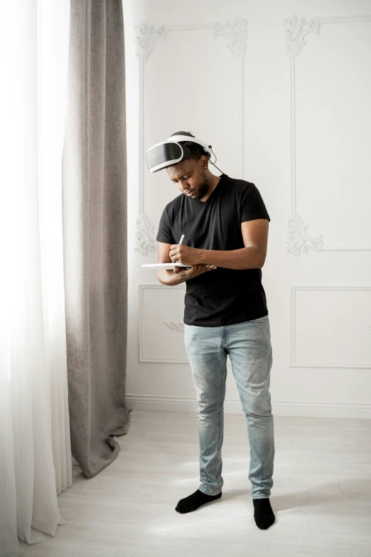 a man wearing a virtual reality headset standing in front of a window, by artist, pexels contest winner, mkbhd, portrait full body, inspect in inventory image, male with halo