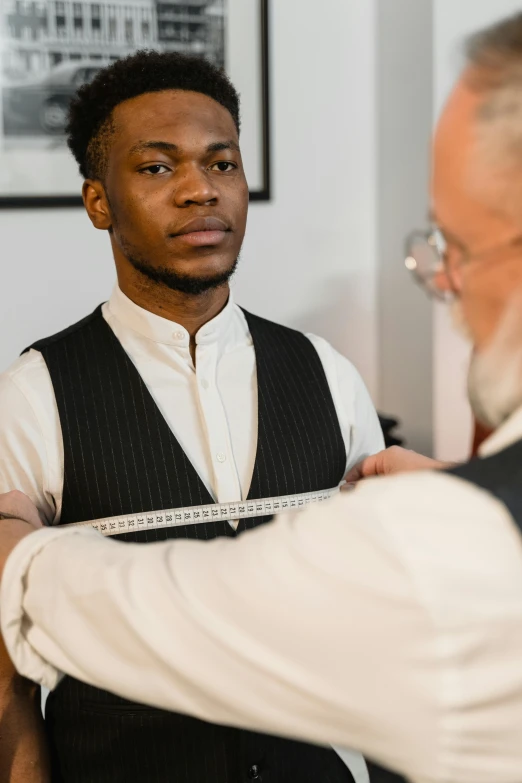 a man adjusting another man's tie in a room, inspired by Barthélemy Menn, trending on unsplash, renaissance, black teenage boy, labcoat, measurements, wearing corset