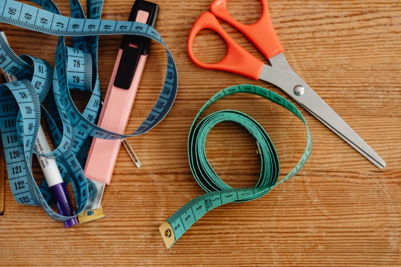 a pair of scissors and a measuring tape on a table, trending on pexels, bandoliers, 9 9 designs, flat - color, super wide