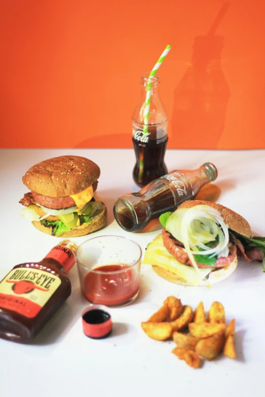 a table topped with burgers and fries next to a bottle of soda, a still life, unsplash, on clear background, food art, belgium, jamaican