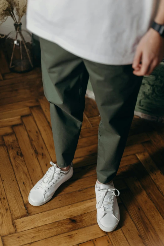 a person standing on a hard wood floor, a picture, by Tobias Stimmer, trending on unsplash, olive green slacks, with short hair, casual streetwear, paper