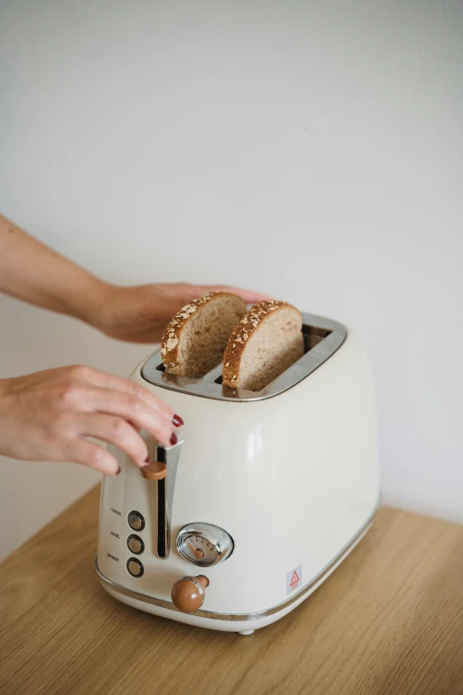 a white toaster sitting on top of a wooden table, by Everett Warner, unsplash, holding a baguette, gif, tall, brown