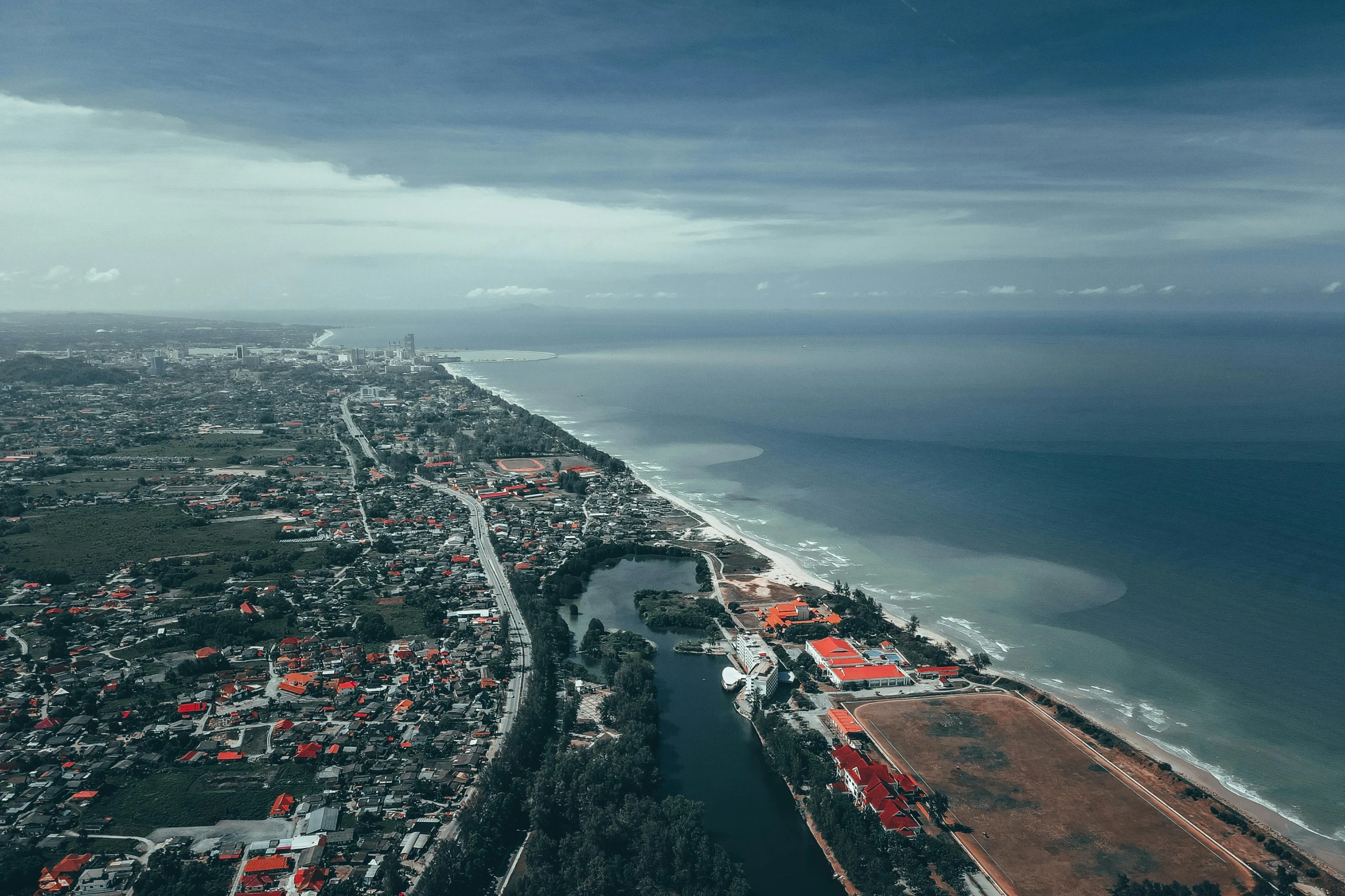 a large body of water next to a beach, by Daniel Lieske, pexels contest winner, hurufiyya, small town surrounding, flight, south jakarta, hd footage