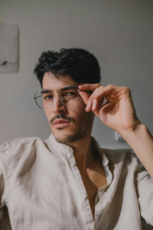 a man in a white shirt holding a pair of glasses, inspired by Camilo Egas, trending on pexels, square masculine jaw, unibrow, non binary model, profile image