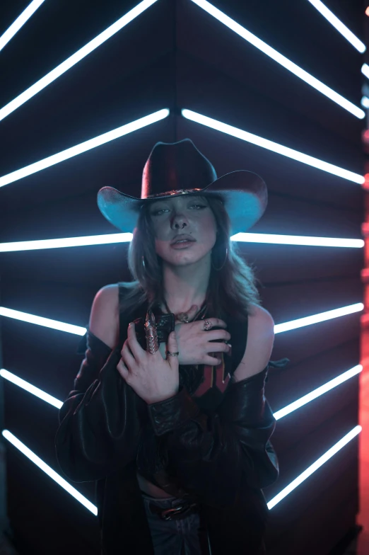 a woman wearing a hat standing in front of neon lights, stoya, black cowboy, official music video, solid background