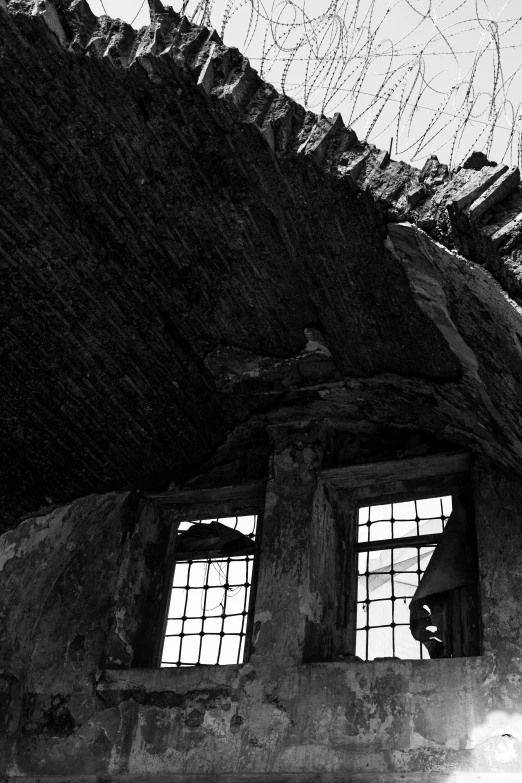 a black and white photo of an old building, unsplash, vorticism, inside a ruined abbey, witch hut, window light, looking upwards