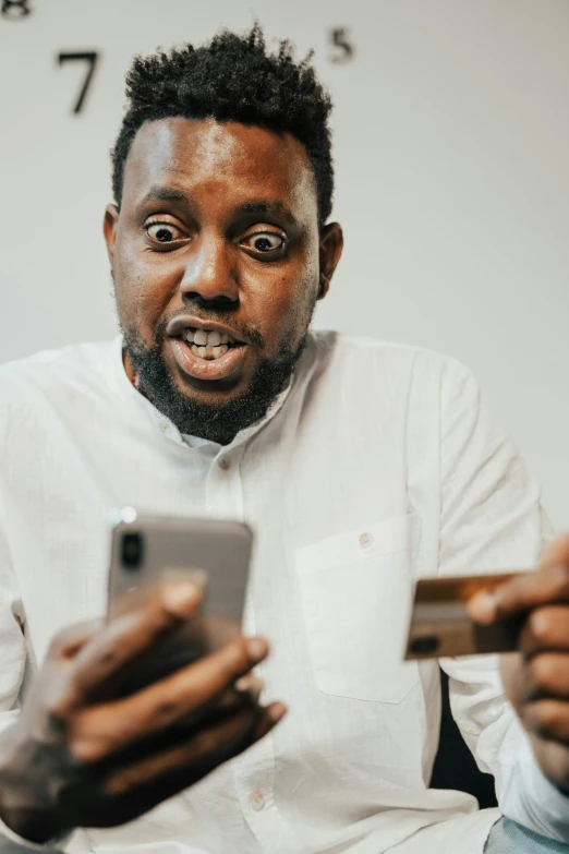 a man holding a credit card and looking at his phone, pexels contest winner, renaissance, expressive surprised expression, riyahd cassiem, portrait of an absurdly ugly, black people