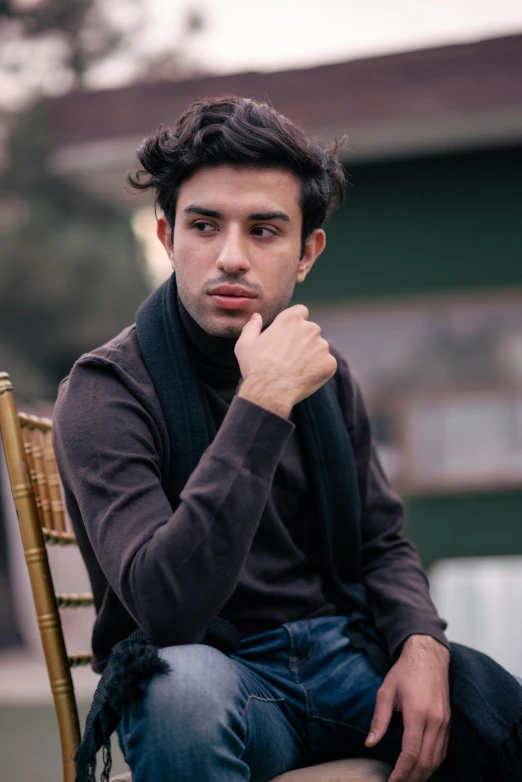 a man sitting on top of a wooden chair, a colorized photo, by Ismail Acar, pexels contest winner, wearing turtleneck, handsome young man, sayem reza, androgynous person
