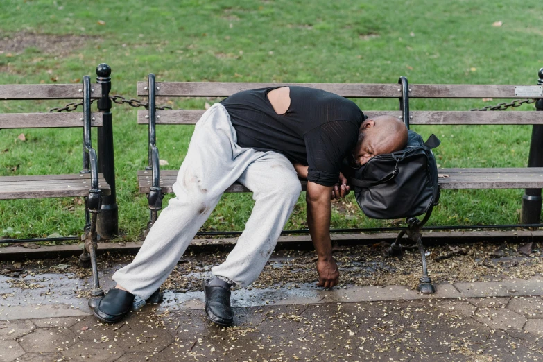 a man is sleeping on a park bench, by Joseph Severn, happening, big drops of sweat, in london, dave chappelle, bags on ground