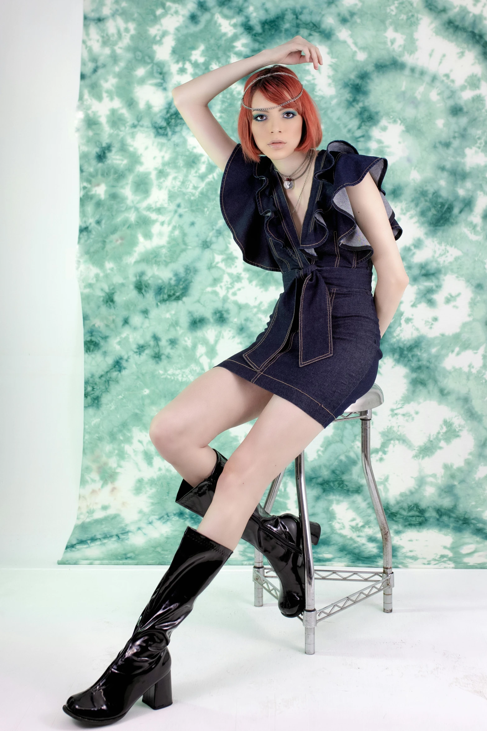 a woman with red hair sitting on a chair, wearing denim, leeloo outfit, pr shoot, high res photograph