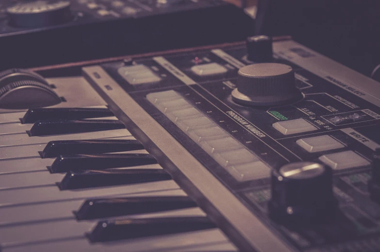 a close up of a keyboard with headphones on, an album cover, unsplash, synthetism, synthesizers, desaturated, the scooter ( edm band, studio lit