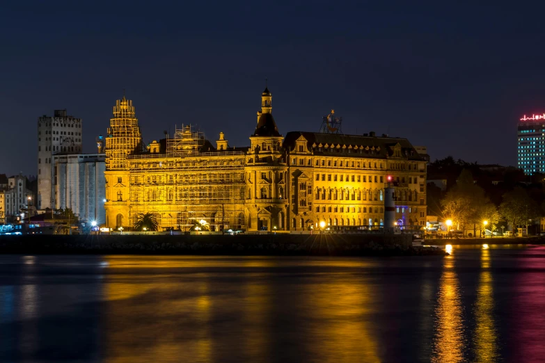 a large building sitting next to a body of water, by Thomas Häfner, pexels contest winner, in the evening, swedish style, victorian buildings, panoramic