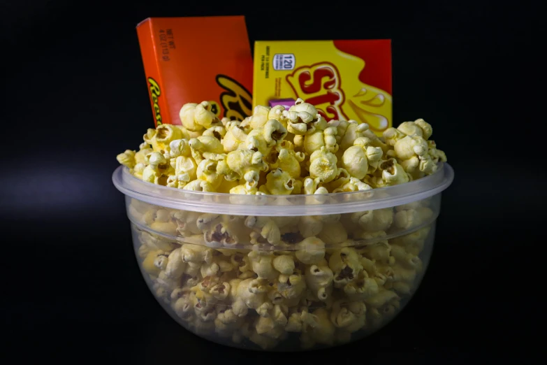 a bowl of popcorn sitting on top of a table, bowl filled with food, in front of a black background, group photo, listing image