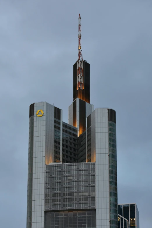 a very tall building sitting in the middle of a city, inspired by Adolf Hölzel, bank, golden dawn, lit from bottom, triangle