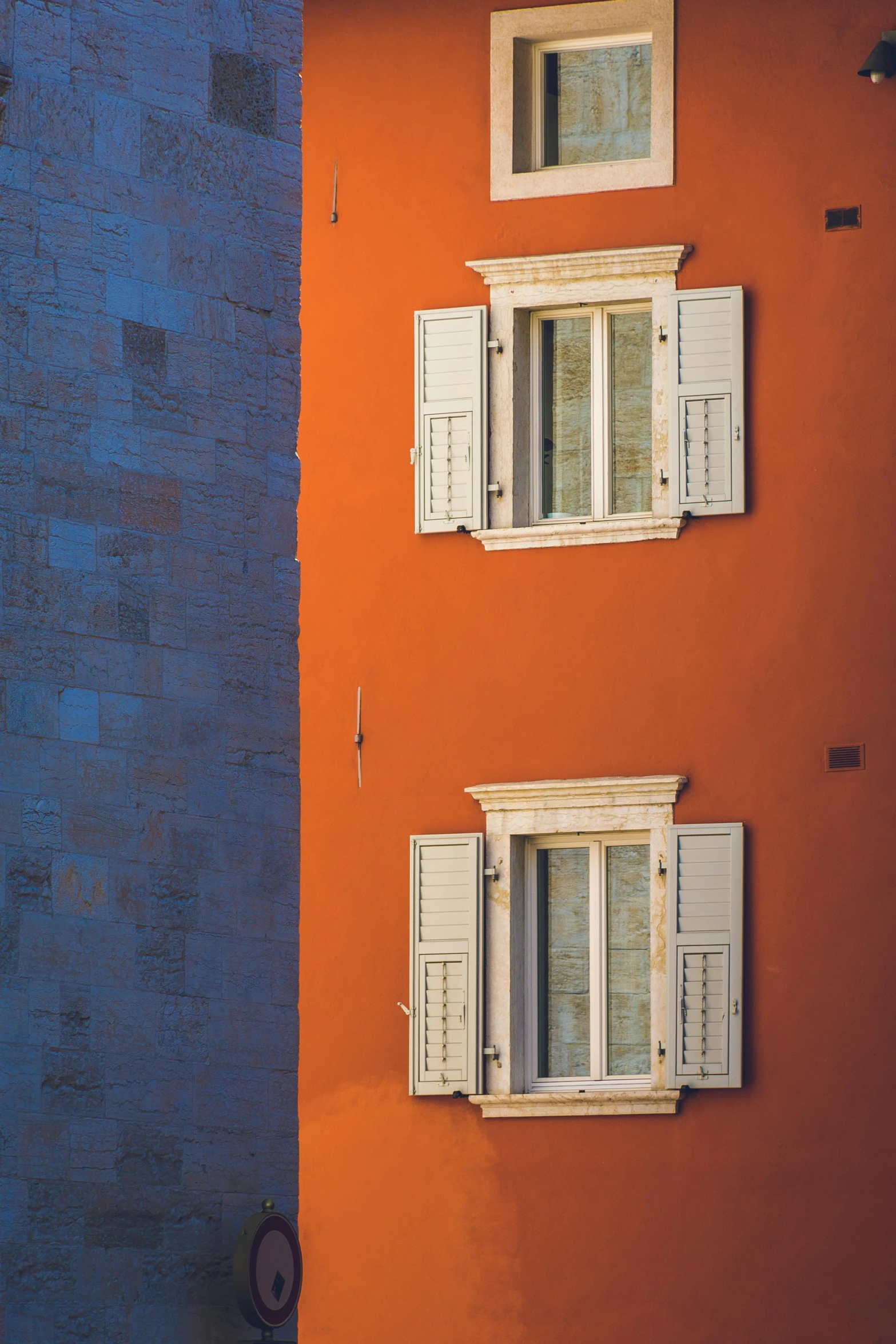 a couple of windows sitting on the side of a building, a picture, inspired by Carlo Maderna, orange palette, multicolor