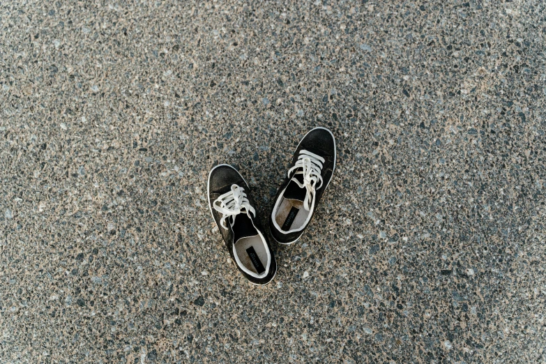 a pair of black and white shoes on the ground, unsplash, avatar image, top angle view, oceanside, black and brown