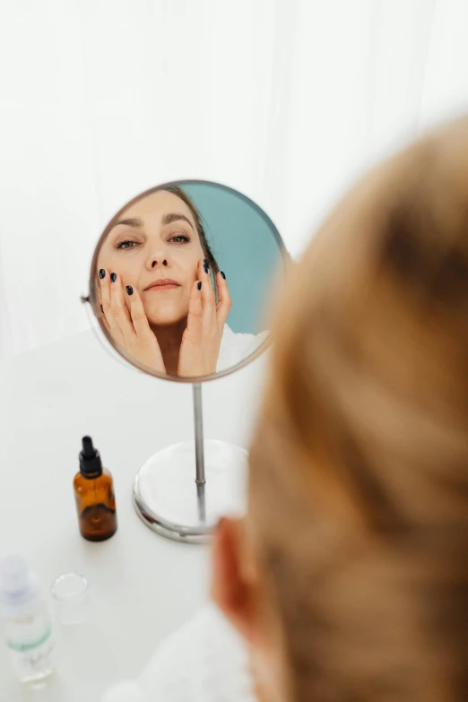 a woman looking at her face in a mirror, dramatic product shot, doctors mirror, facing away from camera, soft face features