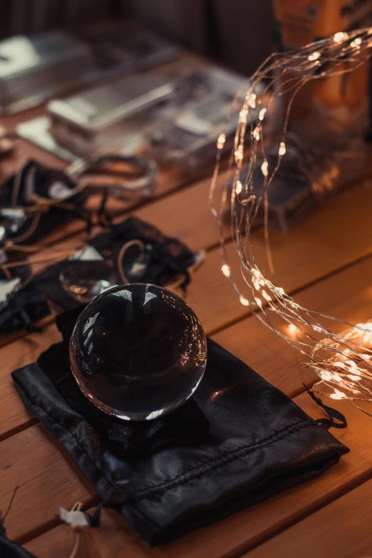 a wooden table topped with lots of lights, trending on pexels, magical realism, black and gold wires, magic spell icon, glass shattering, ecommerce photograph