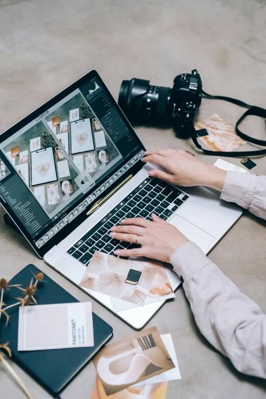 a woman sitting at a table working on a laptop, a picture, by Julia Pishtar, trending on pexels, holding a camera, like a catalog photograph, flat lay, inspect in inventory image