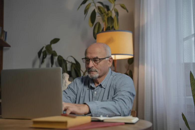 a man sitting at a table using a laptop computer, lynn skordal, neutral lighting, home office, avatar image