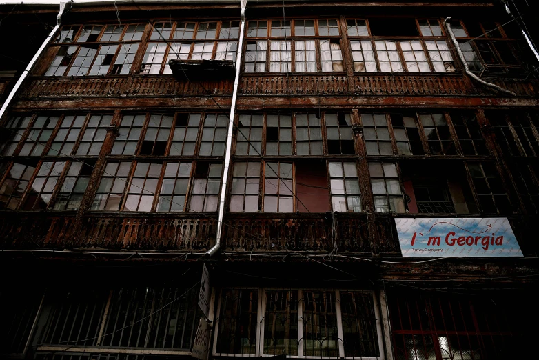 a tall wooden building with lots of windows, an album cover, flickr, mingei, sichuan, abandoned photograph, full frame image