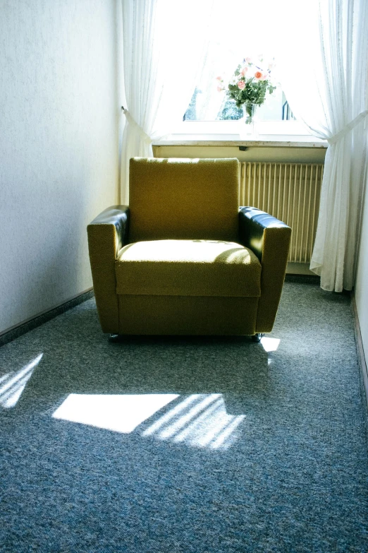 a chair sitting in a room next to a window, an album cover, inspired by Emanuel Schongut, yellow carpeted, 1999 photograph, sun glare, a ghetto in germany