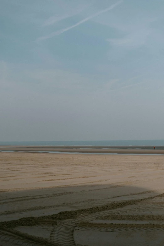 a man flying a kite on top of a sandy beach, a picture, by Thomas de Keyser, wide long view, the normandy landings, very hazy, video