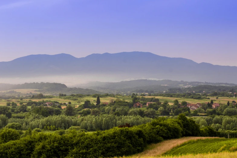 a view of a valley with mountains in the distance, by Adam Szentpétery, pexels contest winner, romanticism, panorama, greenery, pyranees, summer morning