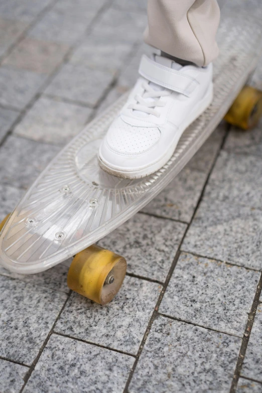 a person riding a skateboard on a sidewalk, inspired by Graham Forsythe, renaissance, made out of clear plastic, soft rim light, a pair of ribbed, white metallic