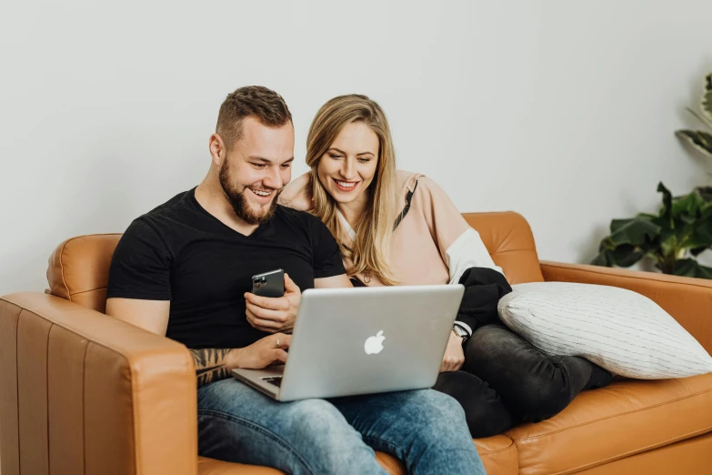 a man and woman sitting on a couch looking at a laptop, trending on pexels, lachlan bailey, avatar image, cute photo, group photo