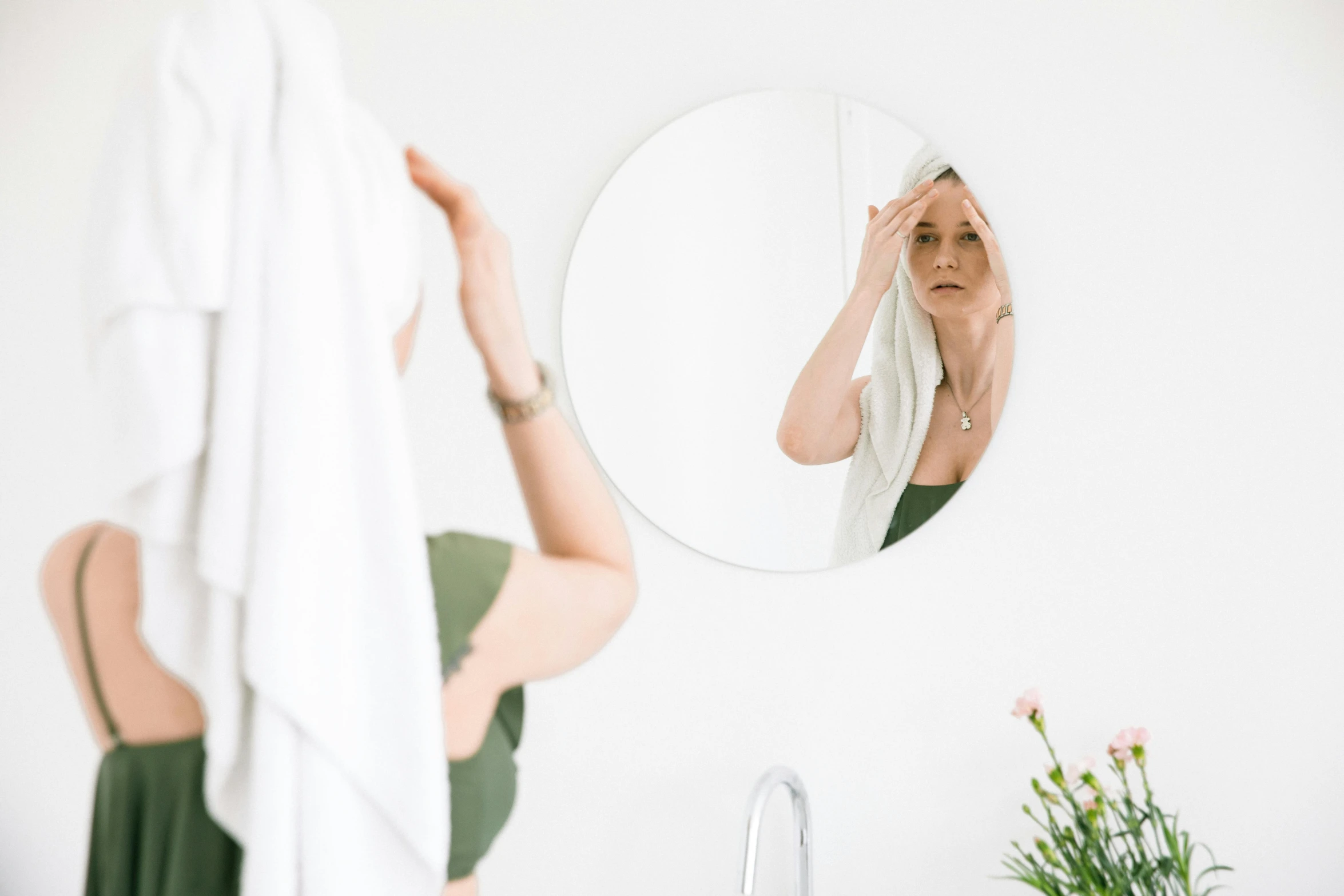 a woman wiping her face in front of a mirror, by Nicolette Macnamara, pexels contest winner, with a white background, wearing a towel, branches sprouting from her head, très détaillé