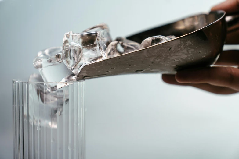 a person is pouring ice into a glass, inspired by Cornelia Parker, trending on pexels, hyperrealism, steel plating, paddle of water, product introduction photo