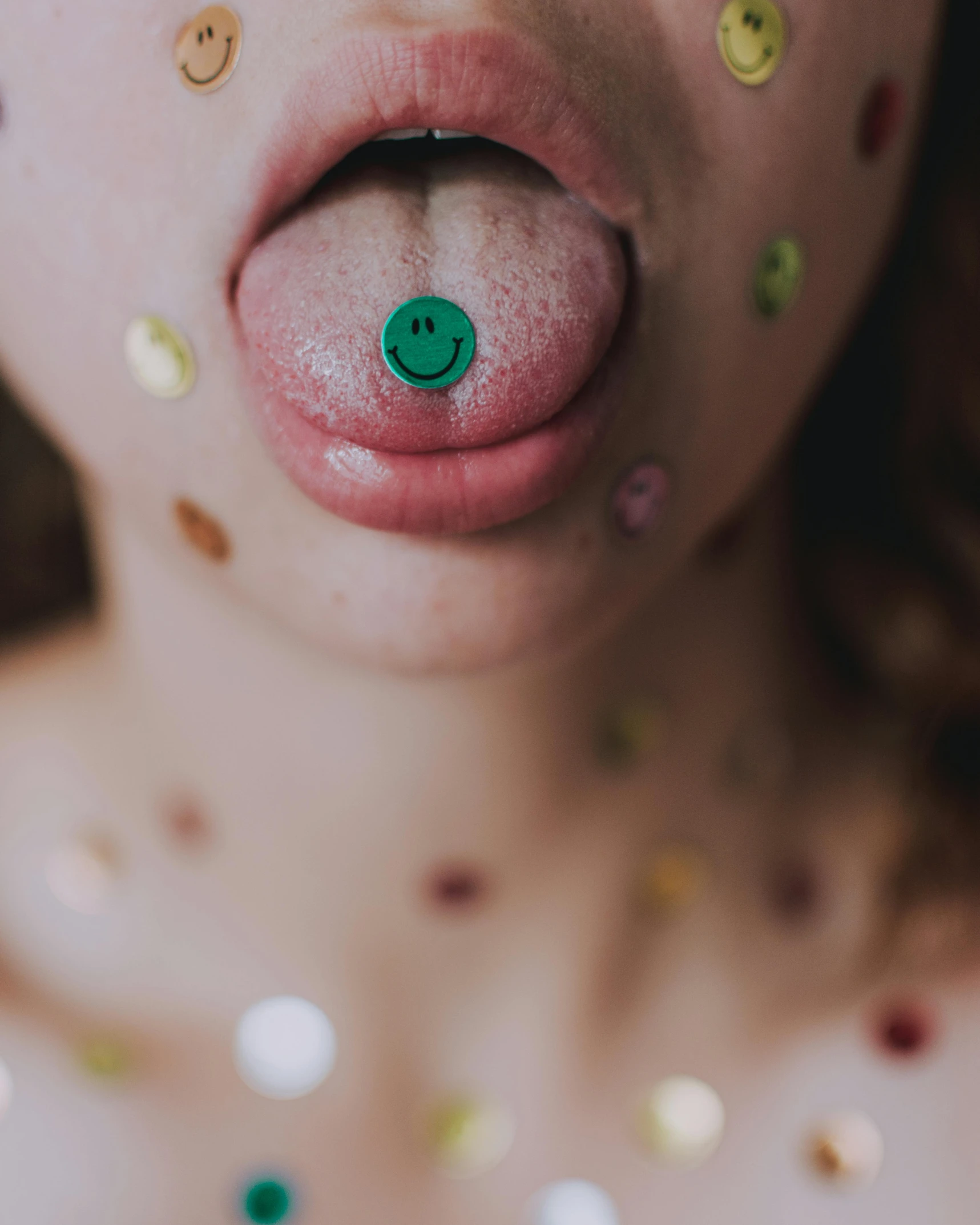 a close up of a child's tongue with confetti on it, inspired by Hedi Xandt, trending on pexels, green body, pierced navel, pale round face, offering the viewer a pill