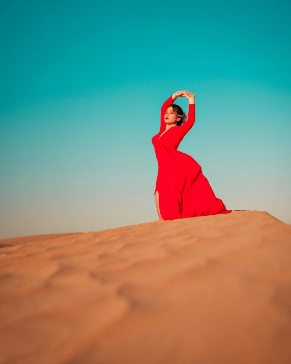 a woman in a red dress in the desert, pexels contest winner, arabesque, doing a majestic pose, bright vivid color hues:1, dune, gif