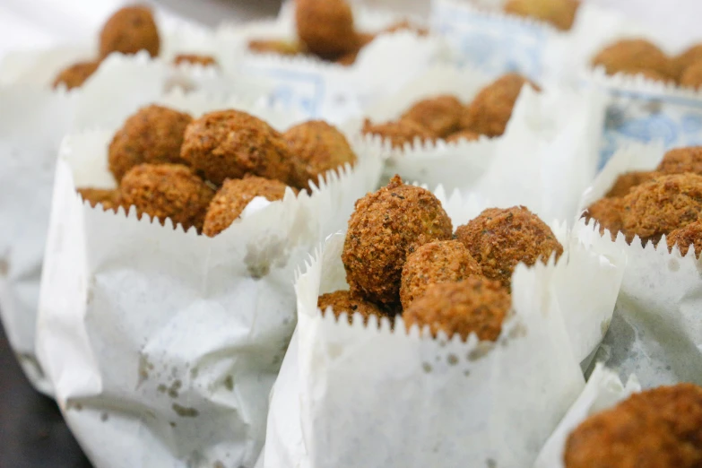 a bunch of food sitting on top of a table, parchment paper, inside an arabian market bazaar, cannonballs, upclose