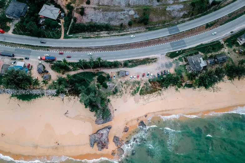 an aerial view of a beach next to the ocean, by Lee Loughridge, pexels contest winner, hurufiyya, colombo sri lankan city street, thumbnail, landslide road, top view of convertible