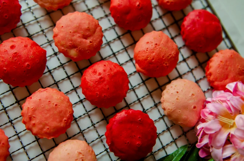 a bunch of doughnuts sitting on top of a cooling rack, art nouveau, covered with pink marzipan, very red colors, balls of rice, thumbnail