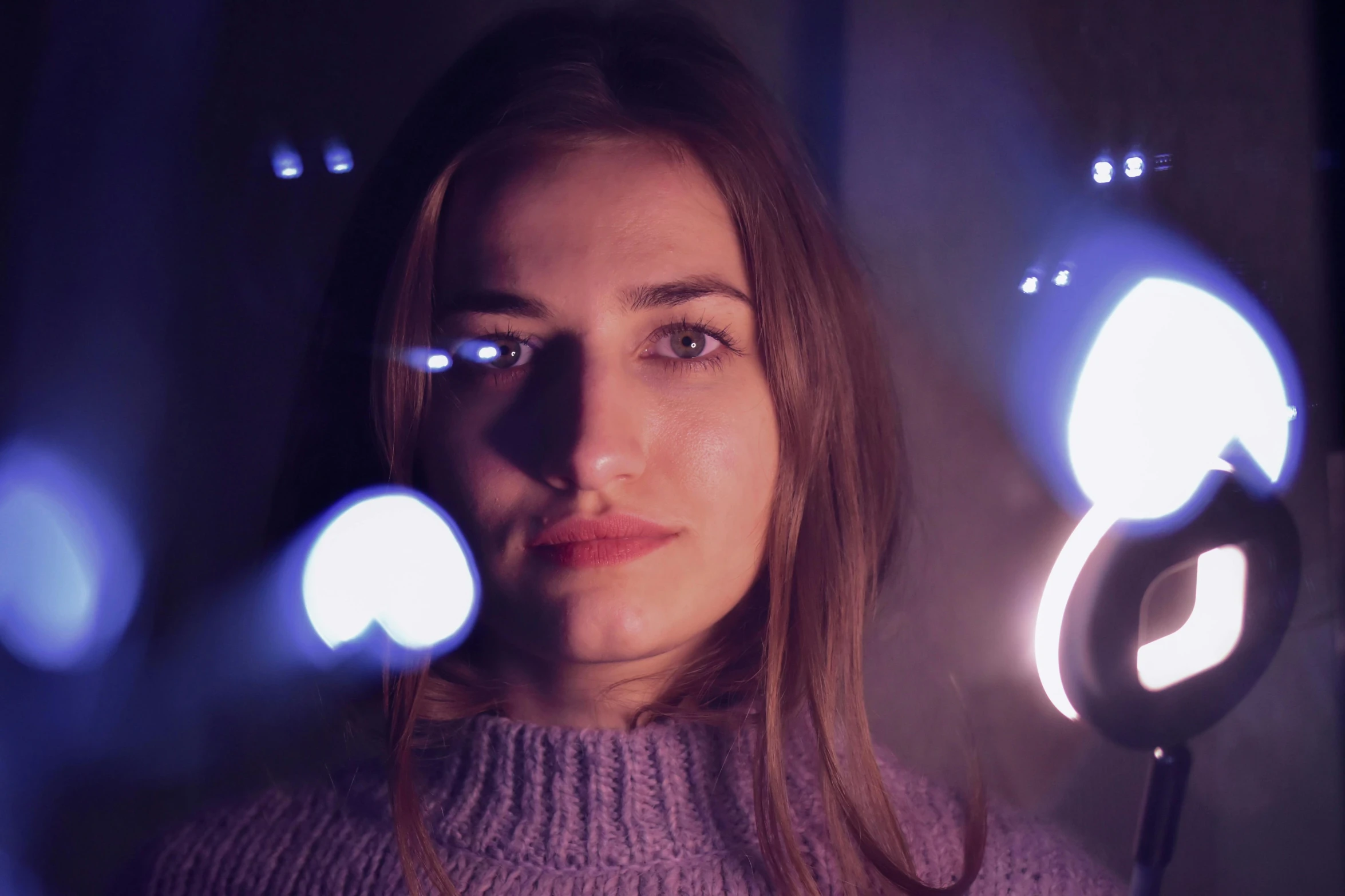 a woman holding a pair of scissors in front of her face, inspired by Elsa Bleda, pexels contest winner, photorealism, floating lights, volumetric lighting 8 k, grainy movie still, infinity mirror