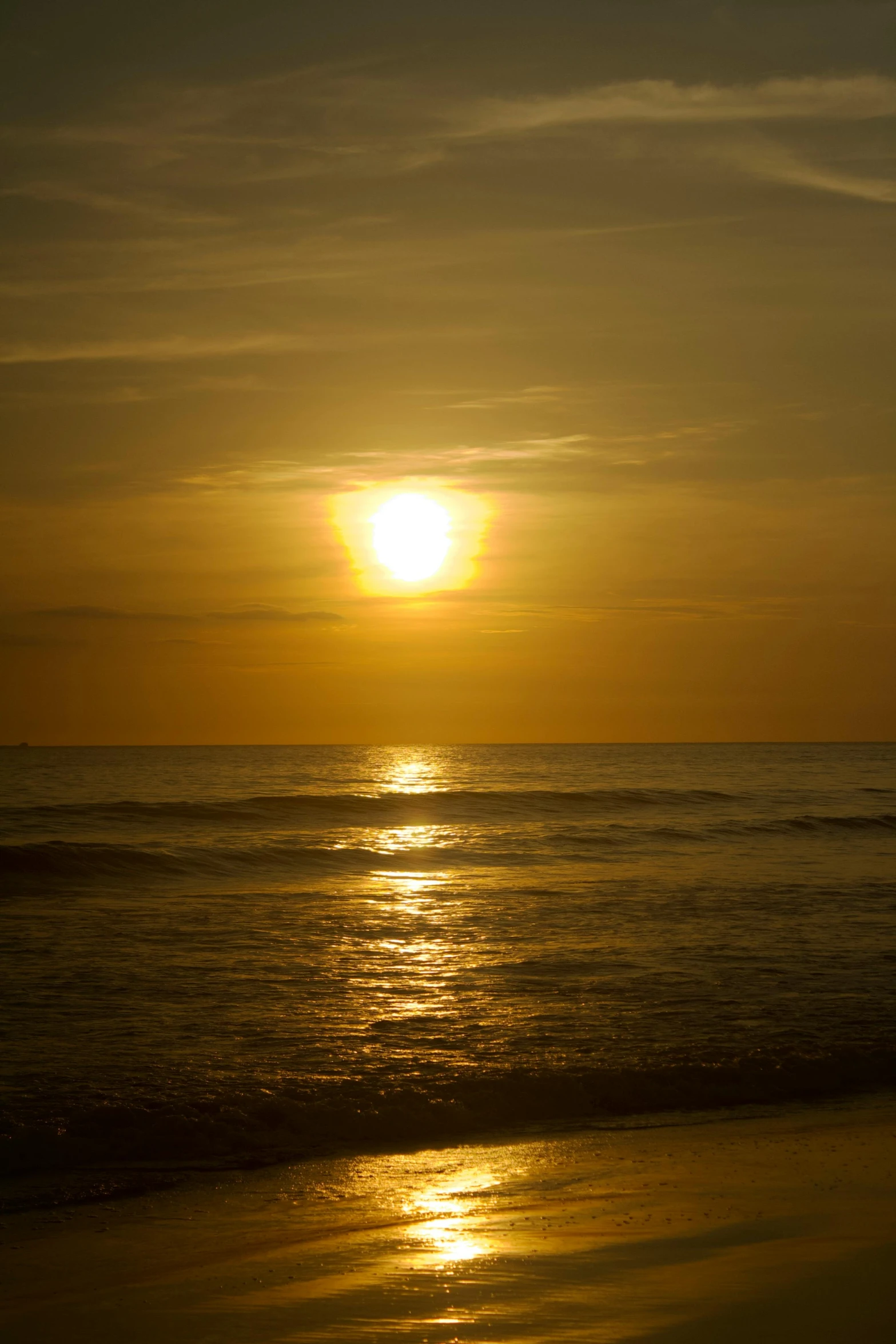 the sun is setting over the water on the beach, ((sunset)), varadero beach, golden glistening, -n 9