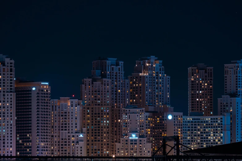 a view of a city at night from a bridge, by Ryan Pancoast, stacked buildings, full frame image, digital banner, blue night