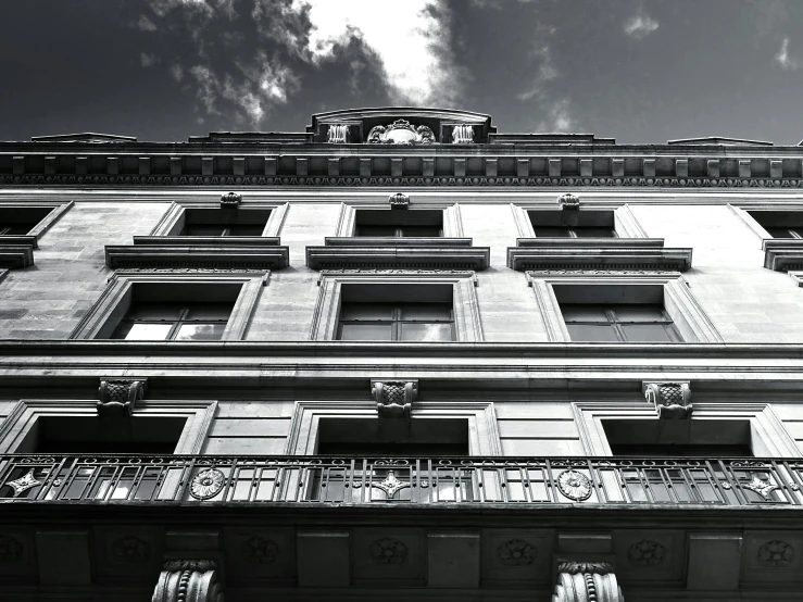 a black and white photo of a tall building, a black and white photo, pexels contest winner, neoclassicism, freddy mamani silvestre facade, architectural visualization, nice afternoon lighting, low angle!!!!