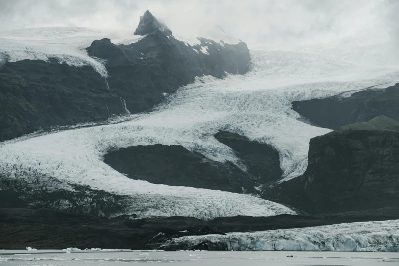 a mountain covered in snow next to a body of water, inspired by Þórarinn B. Þorláksson, pexels contest winner, hurufiyya, icy glaciers, on a gray background, cinematic photo 4k, a still of an ethereal