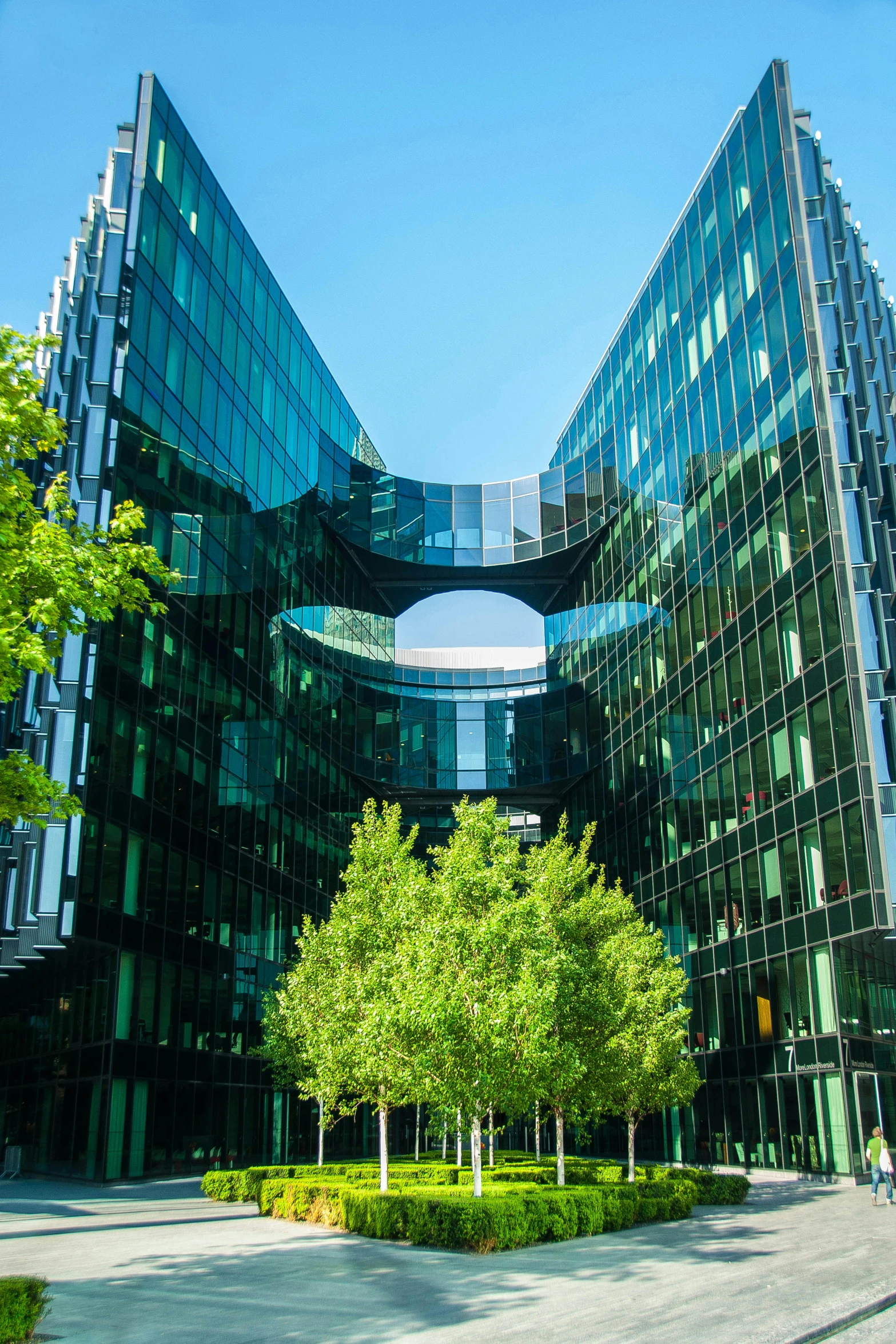 a couple of buildings that are next to each other, inspired by Zaha Hadid, vibrant greenery, berlin, high-quality photo, green square