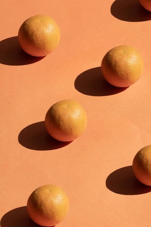 a group of oranges sitting on top of a table, by Doug Ohlson, trending on pexels, conceptual art, subtle pattern, cannonballs, light tan, looking off to the side