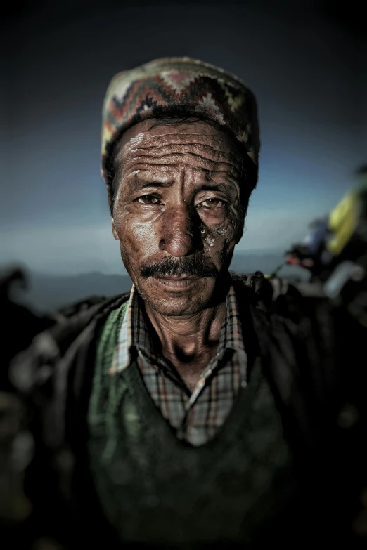 a man that is standing in the dirt, an album cover, inspired by Steve McCurry, sumatraism, rising from mountain range, finely detailed facial features, an elderly, nepal