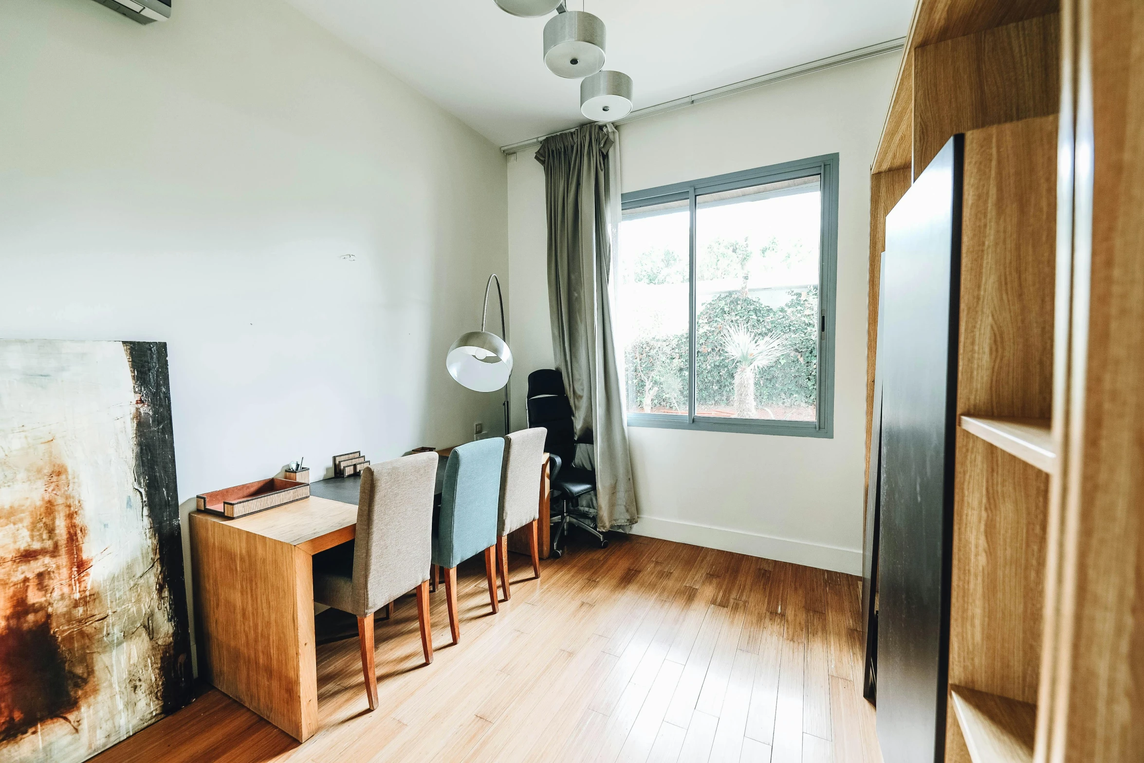 a living room filled with furniture next to a window, by Simon Gaon, light and space, home office, bare room, clean room, wooden floors