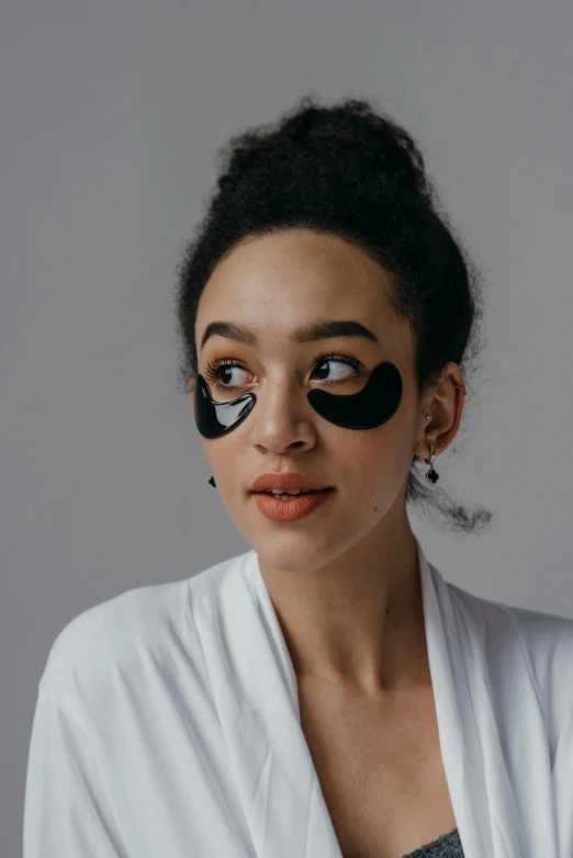 a woman with eye patches on her face, by Julia Pishtar, trending on pexels, wavy, made of smooth black goo, product photo, light skin