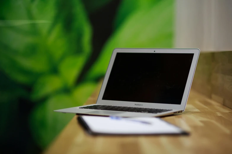 a laptop computer sitting on top of a wooden desk, pexels, green and white, green wall, rectangle, brown