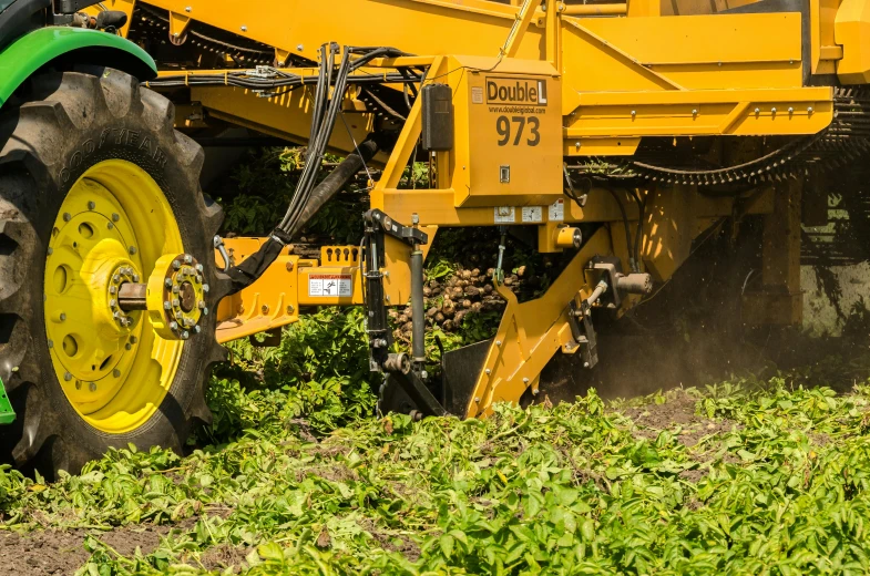 a tractor that is sitting in the grass, pulling weeds out frantically, mustard, production ready, high-body detail